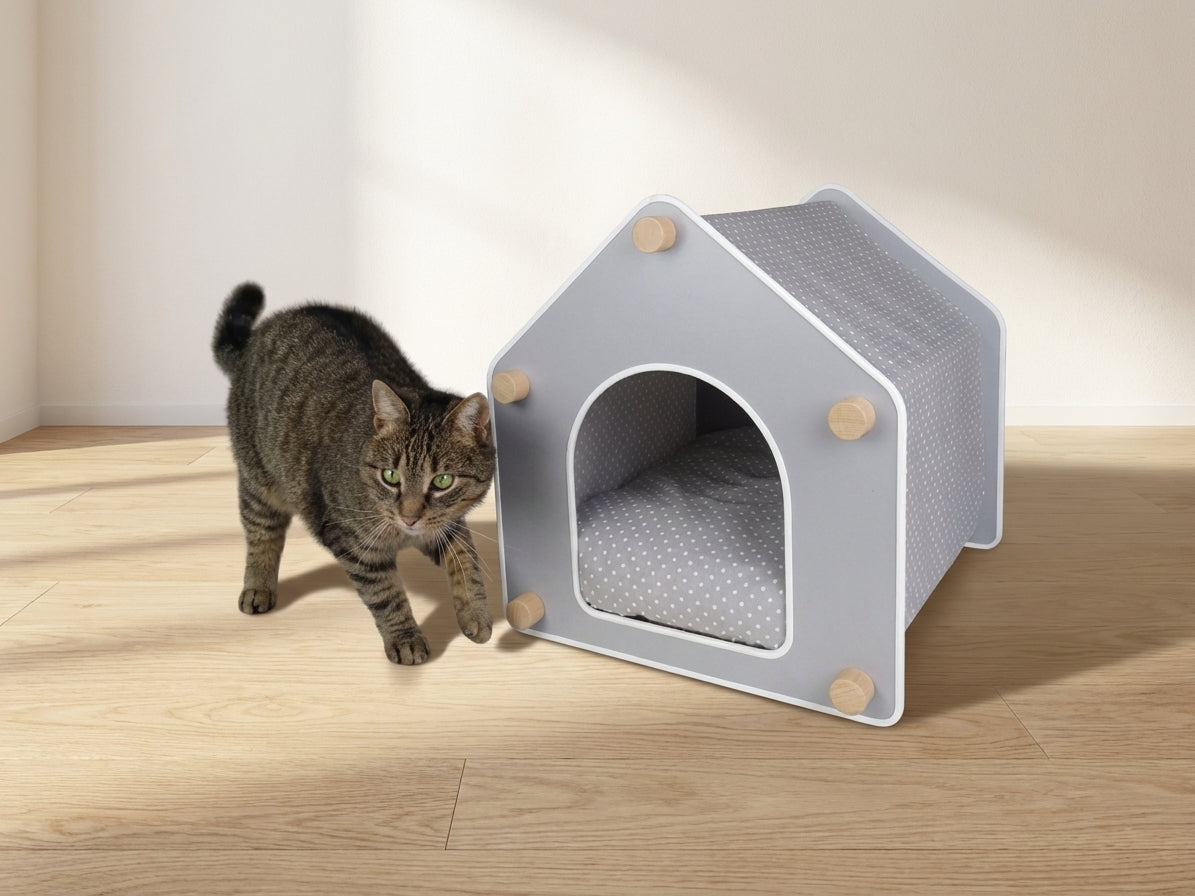 A cat resting inside a freestanding designer cat house on a cushioned base