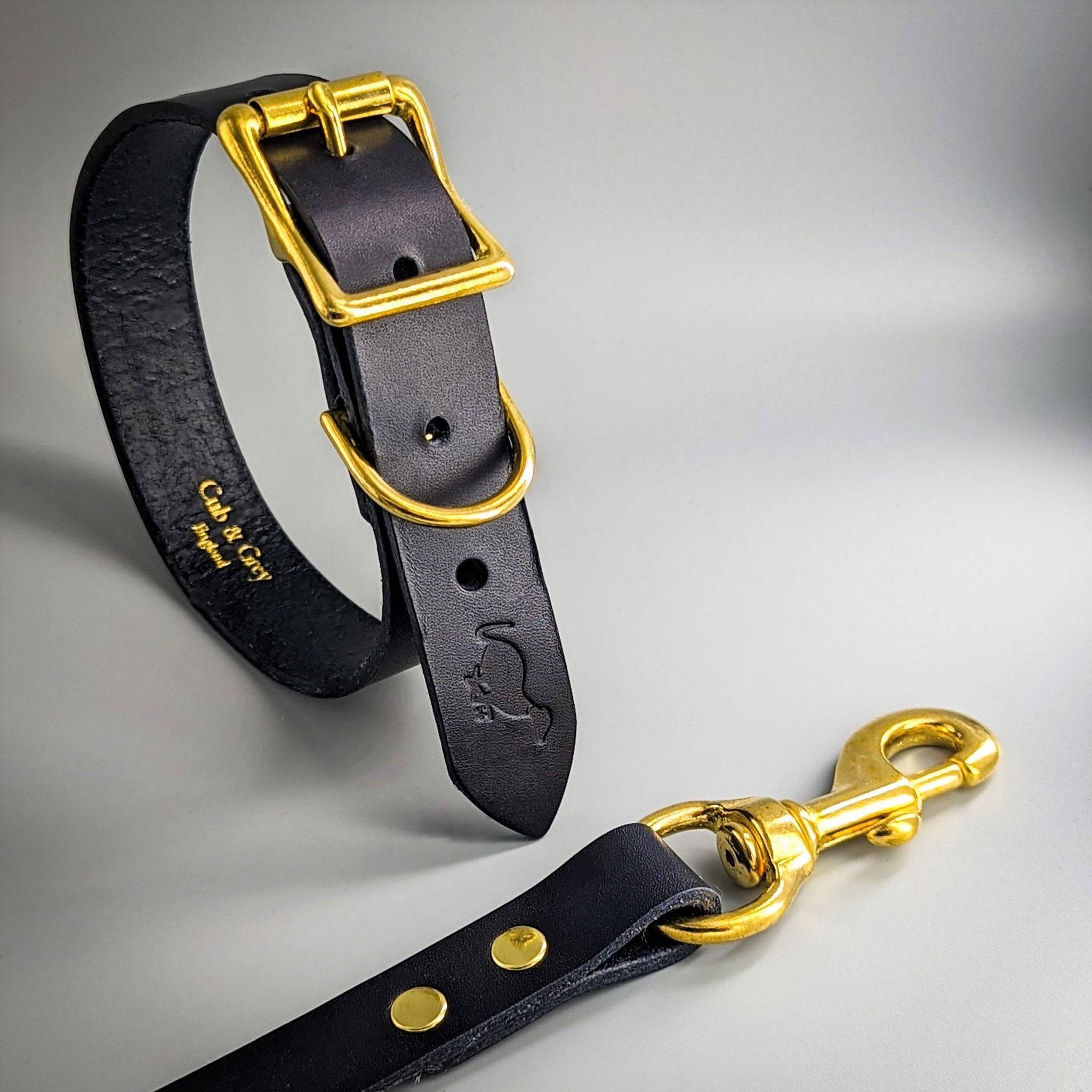 Black personalised leather dog collar and lead set with gold-tone square buckle and embossed paw print design