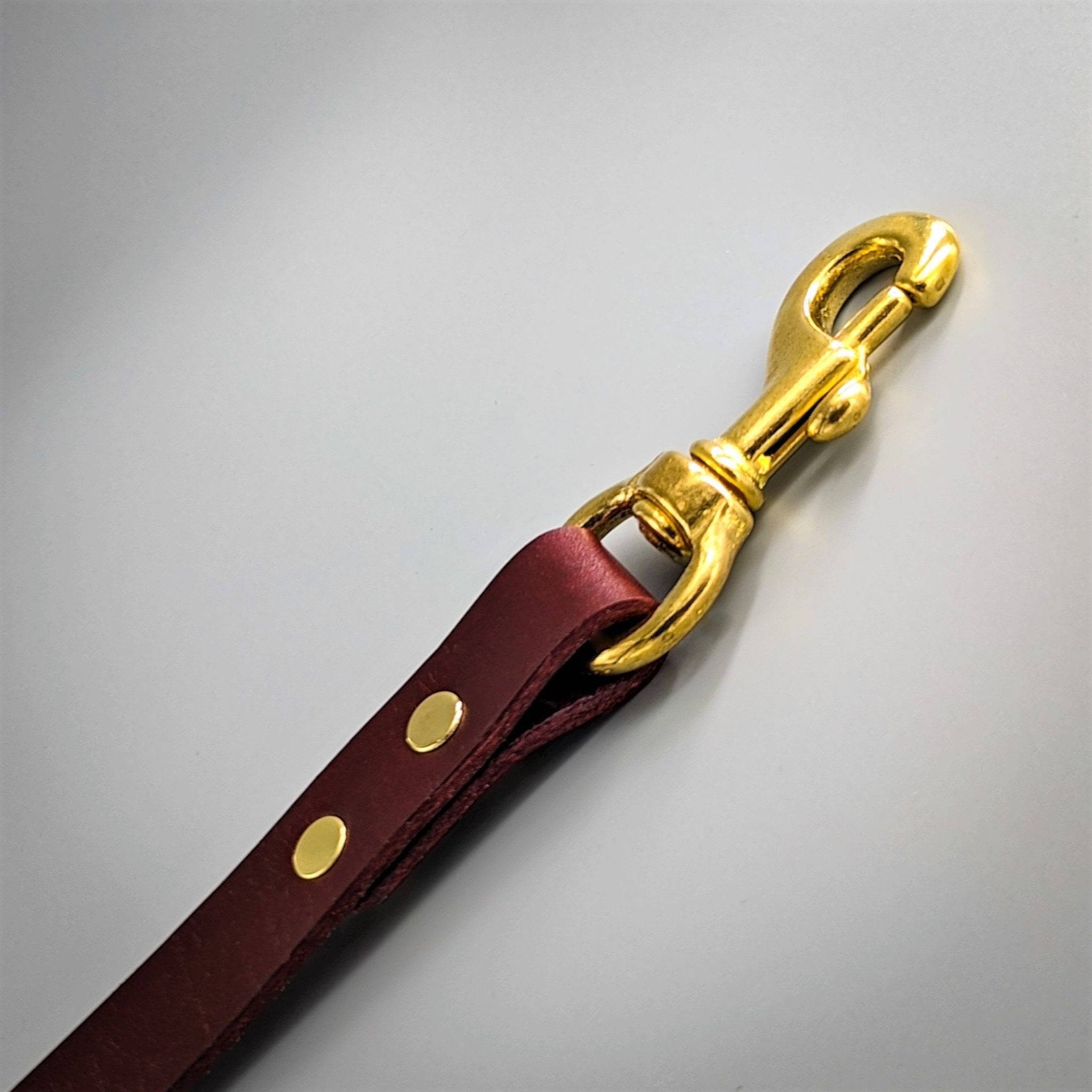 Close up of a Cub & Grey British Burgundy leather dog lead with brass hardware