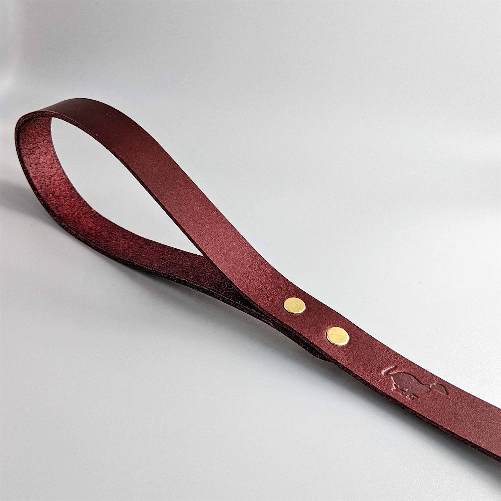 Close-up of a British Burgundy Cub & Grey leather dog lead on a white background
