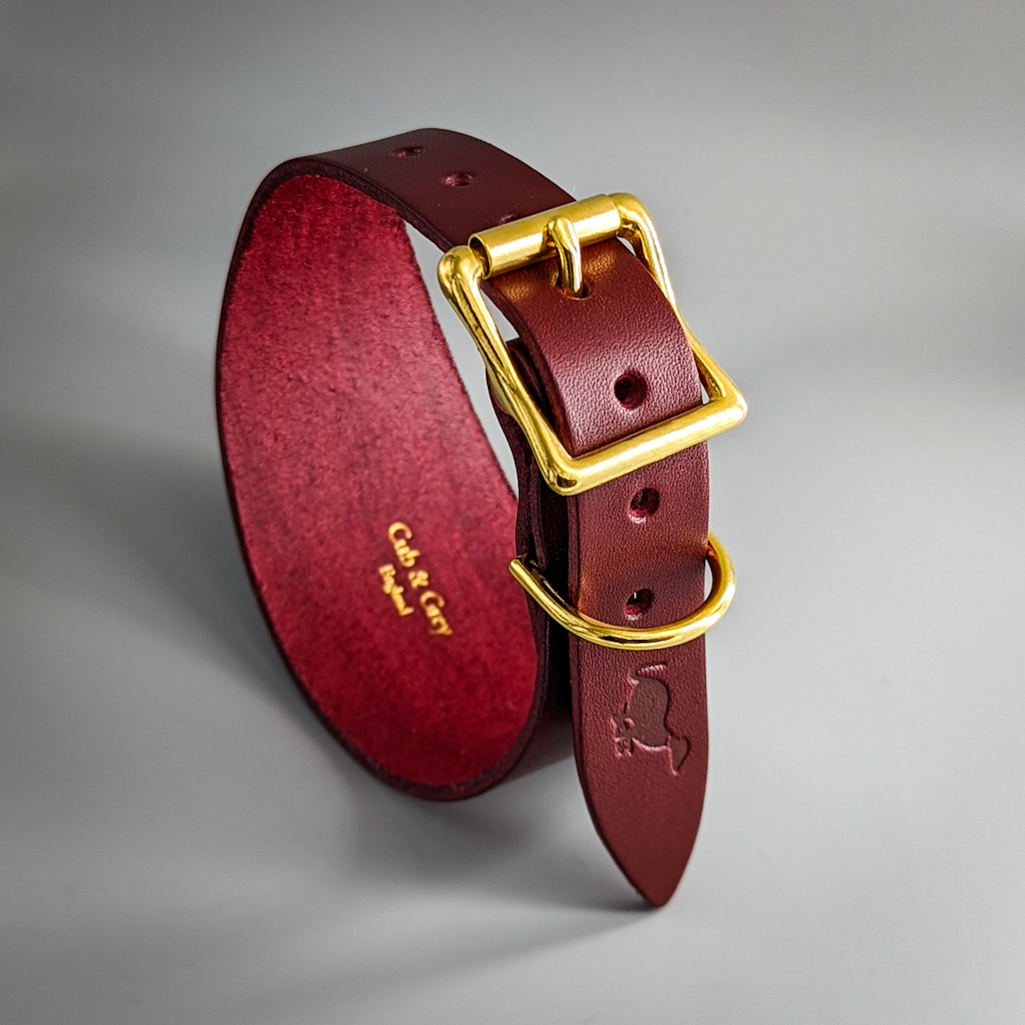 Burgundy leather whippet collar with brass square buckle and red suede interior featuring Carl & Co branding
