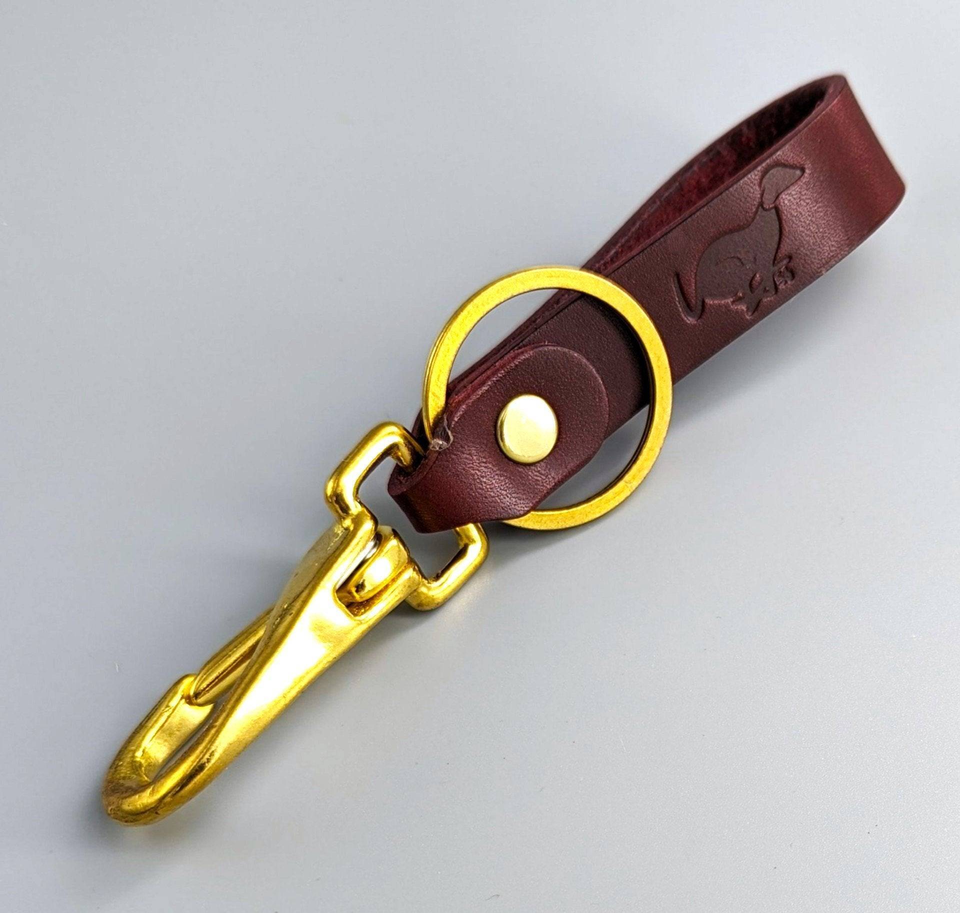 Rich burgundy British leather keyring with brass swivel clasp featuring embossed personalization and rivet details