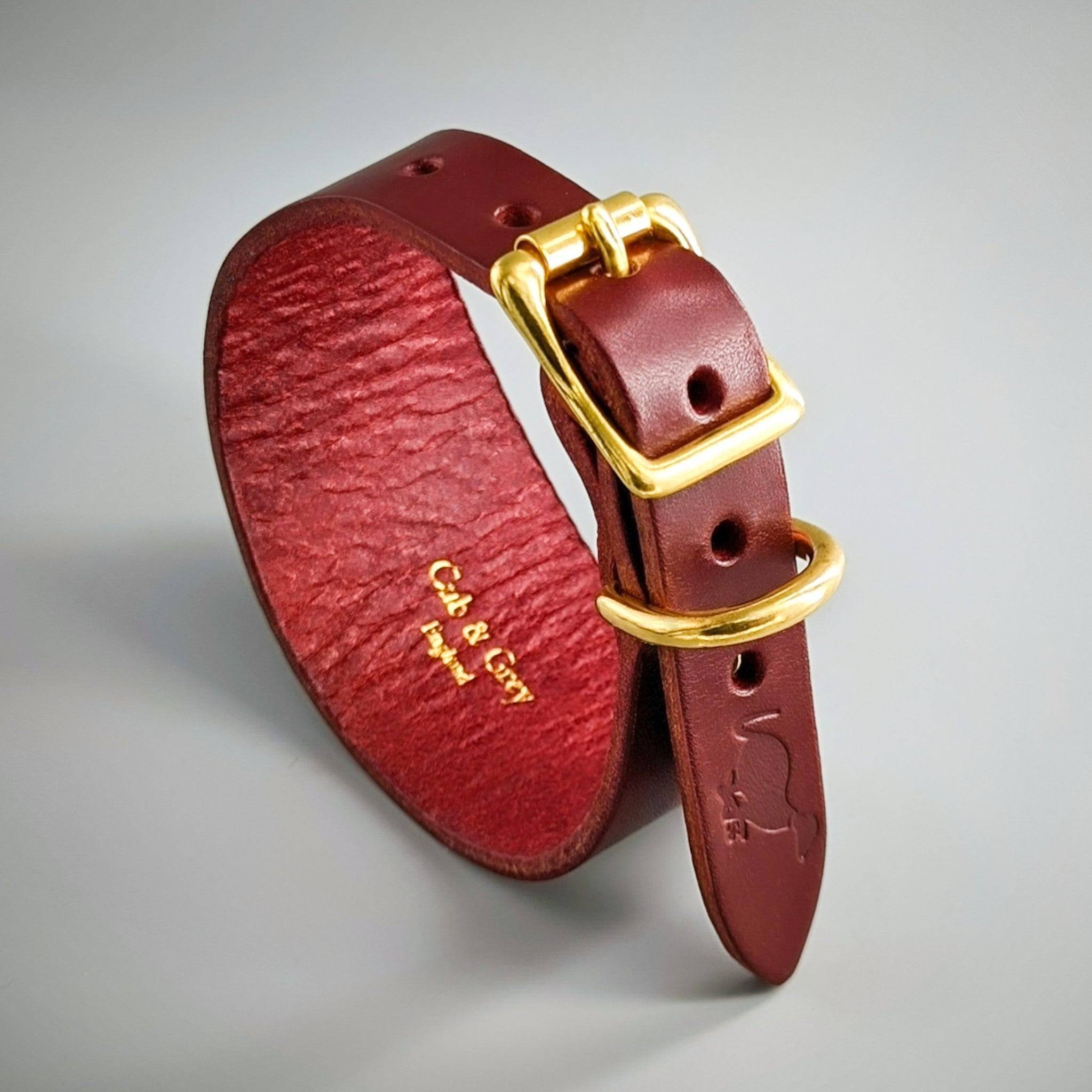 Burgundy leather dog collar gold buckle D-ring curved position, textured interior embossed lettering premium craft