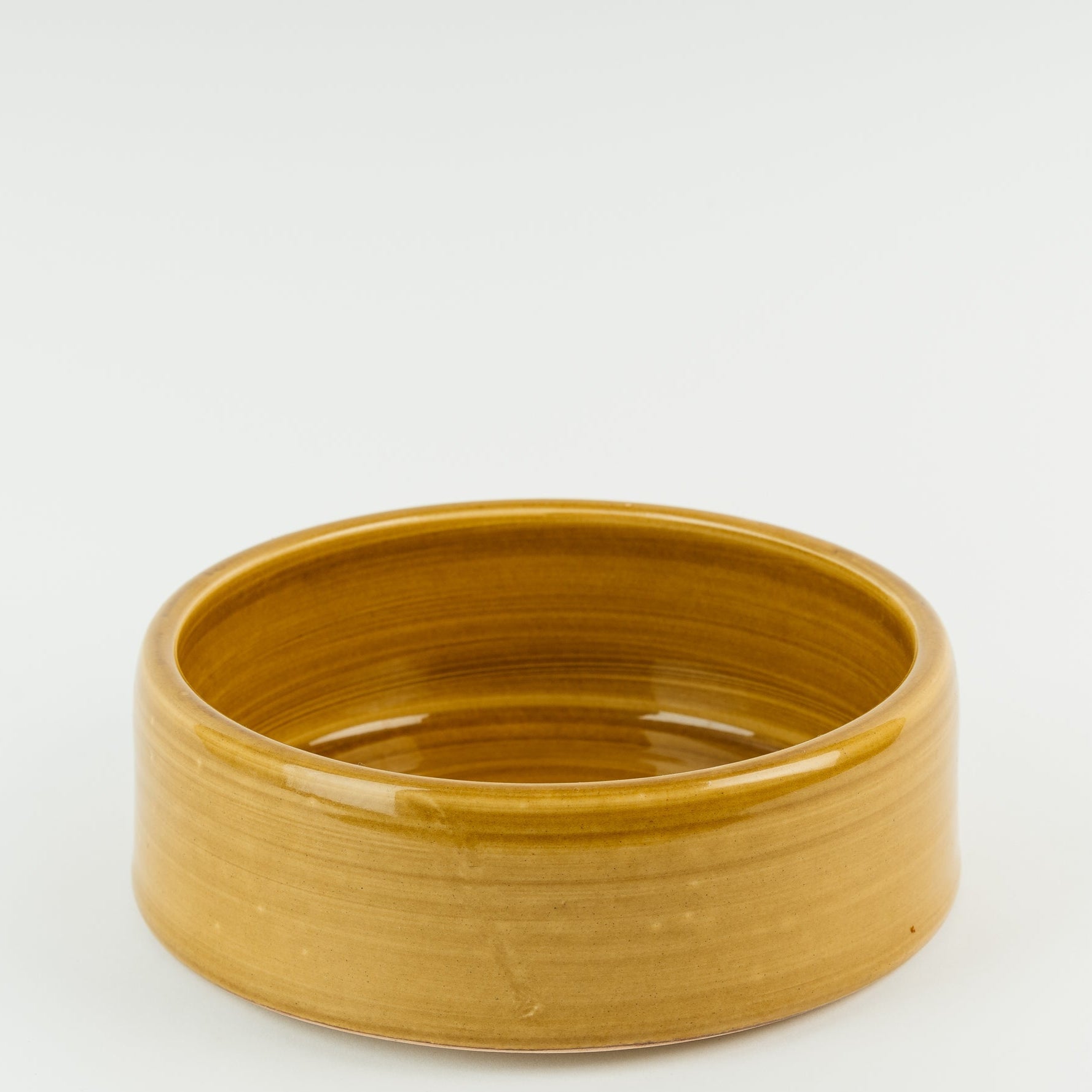 Handmade British ceramic dog bowl in golden stoneware with visible pottery rings, artisan crafted Derbyshire pottery
