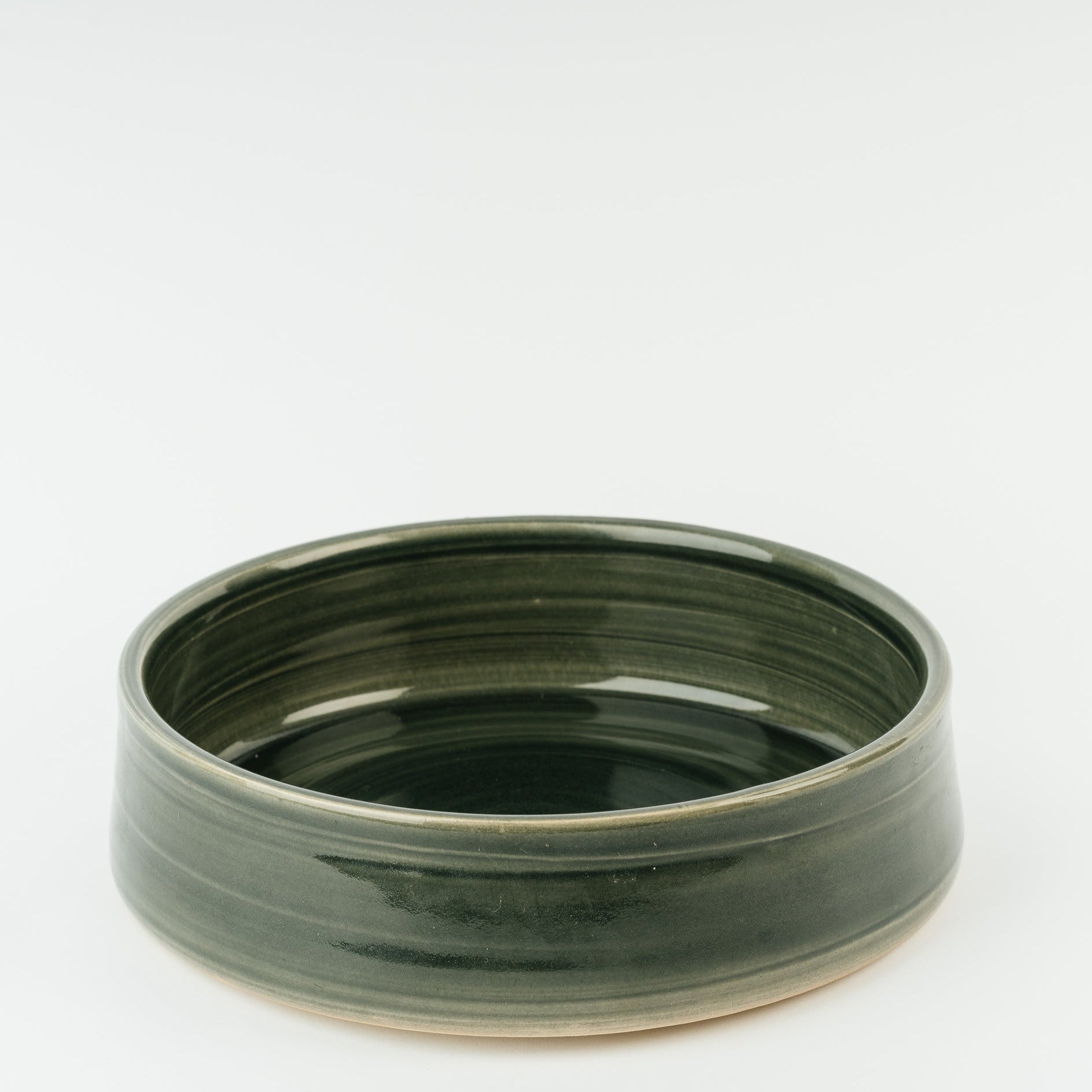 Handmade green ceramic dog bowl with ridged interior design, artisan British stoneware pottery from Derbyshire