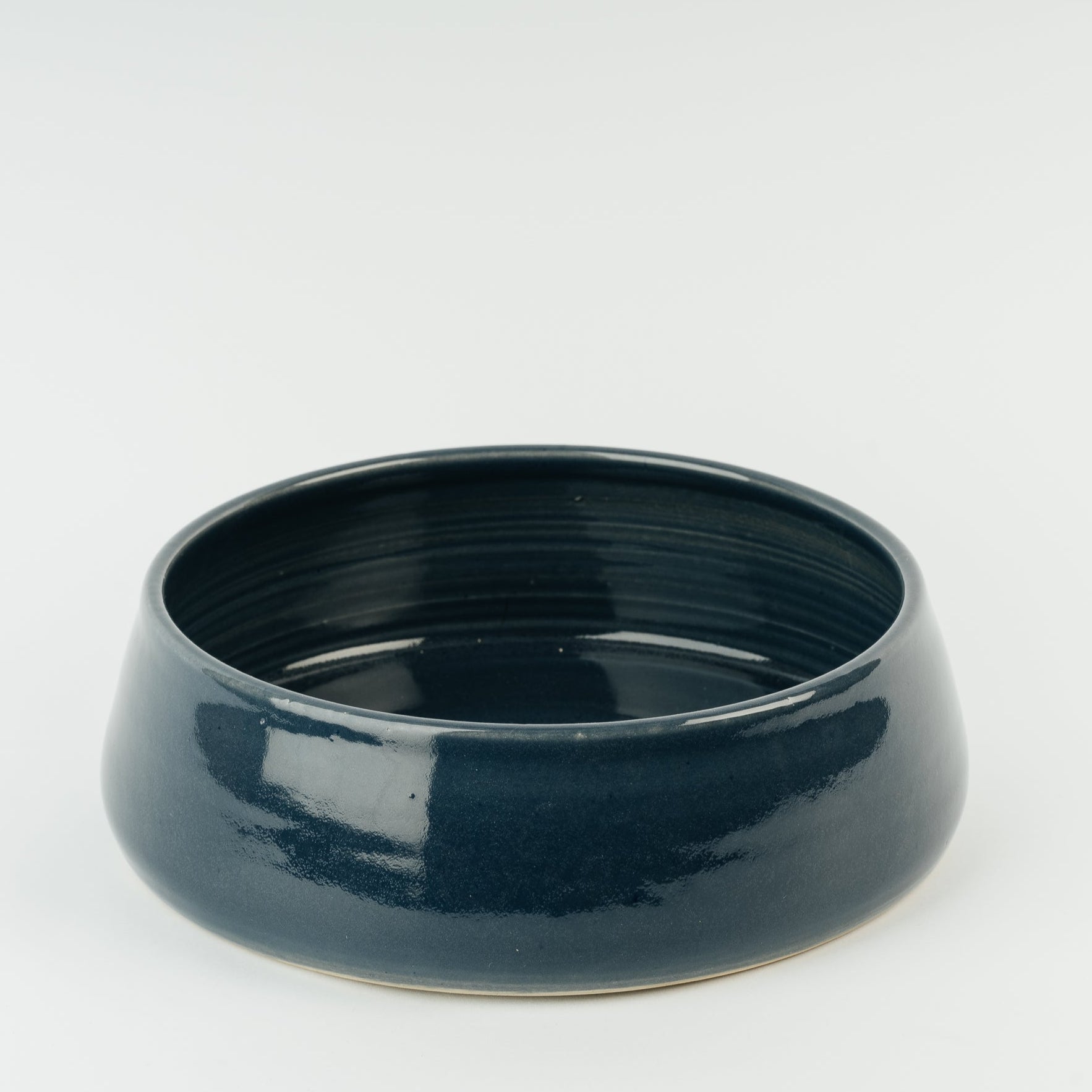 Large handmade stoneware dog bowl in deep teal glaze, showing traditional British pottery craftsmanship and artisan quality