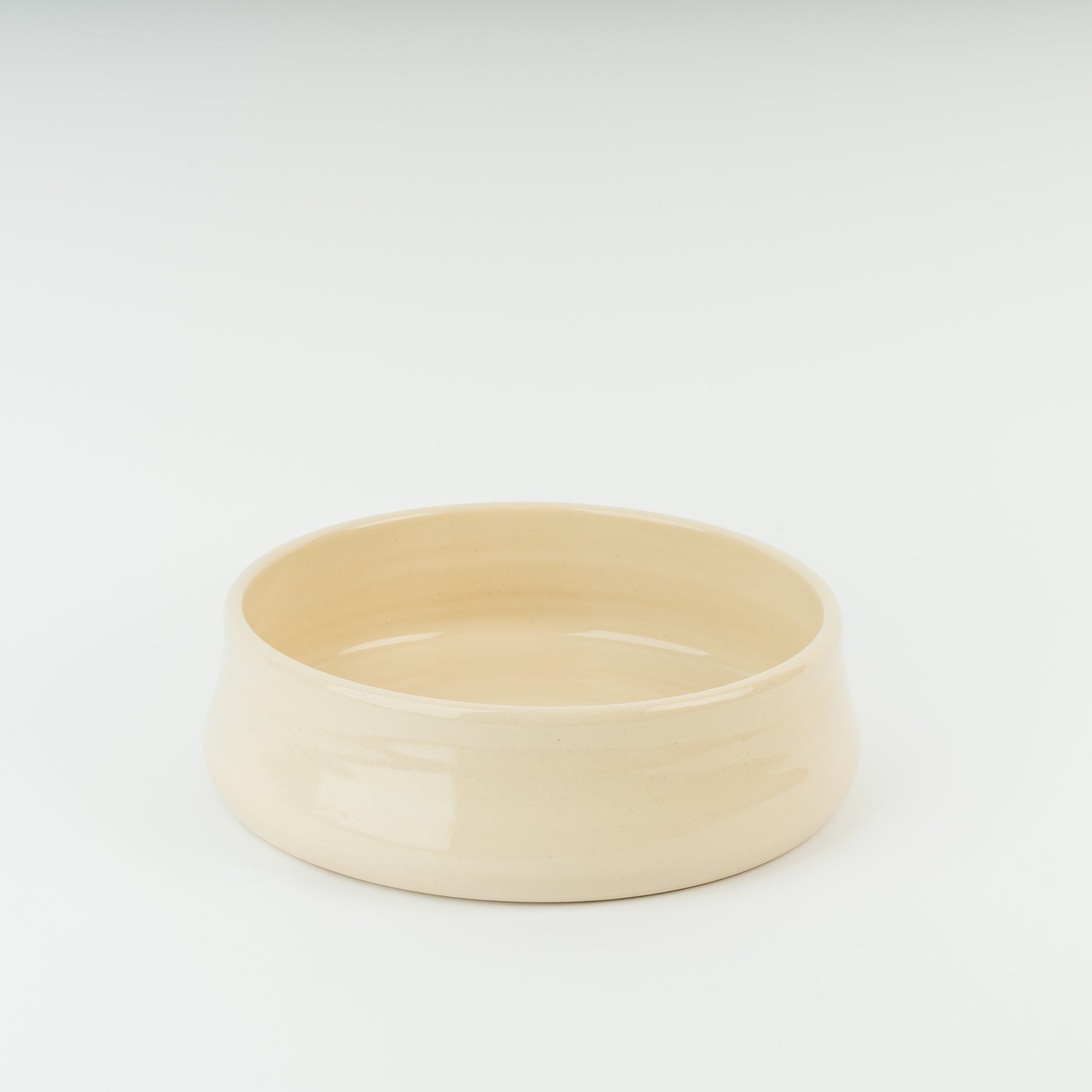 Handmade cream stoneware dog bowl from British Derbyshire pottery, showing artisan crafted ceramic pet feeding dish