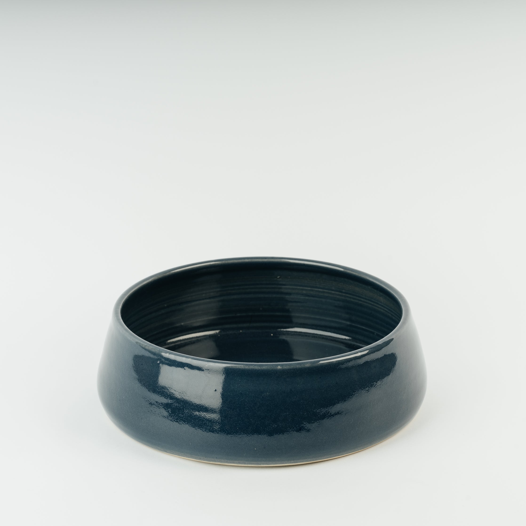 Handmade dark blue ceramic dog bowl in Derbyshire stoneware, showing artisan pottery craftsmanship and glazed finish