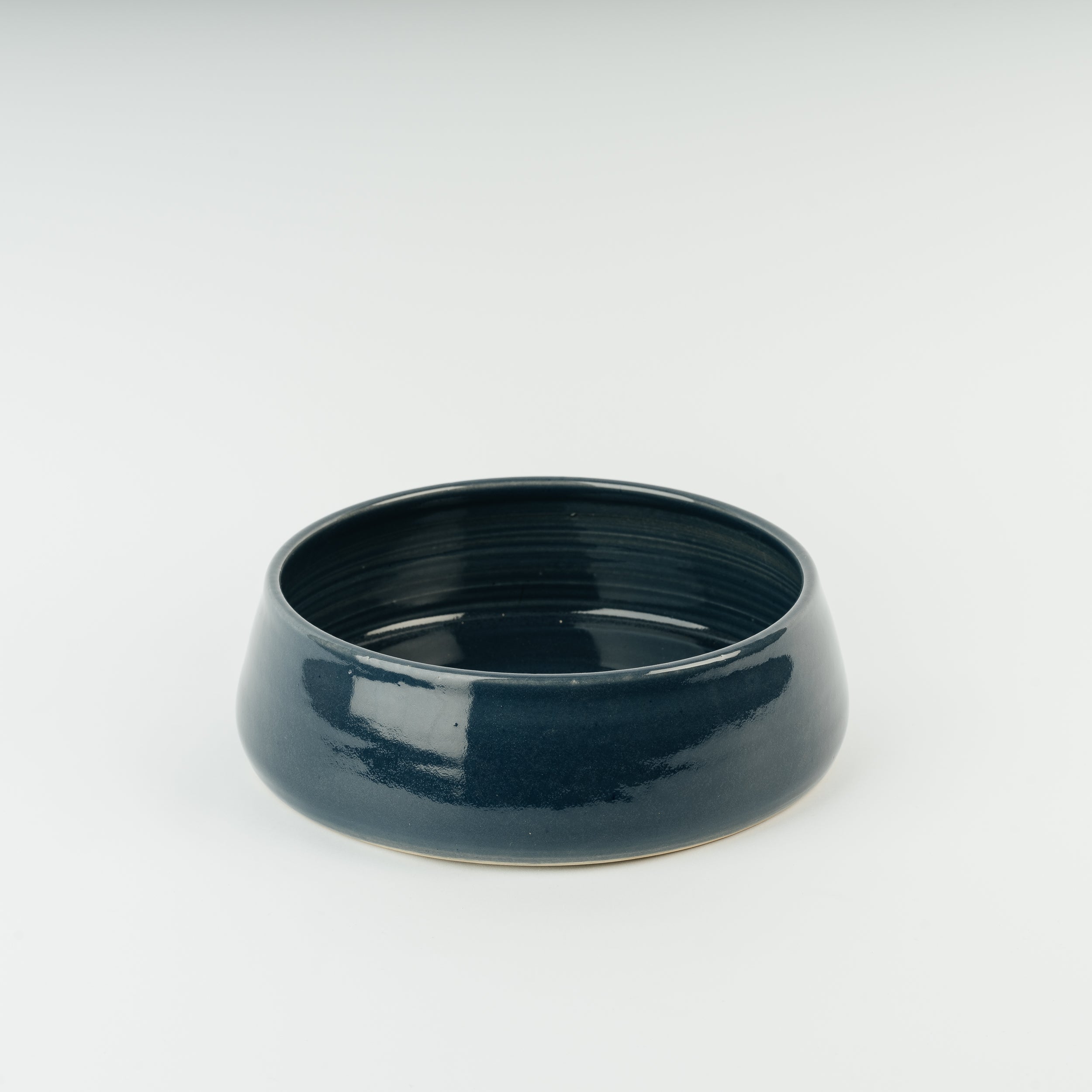 Handmade British ceramic dog bowl in deep teal glaze, artisan stoneware pet dish from Derbyshire pottery tradition