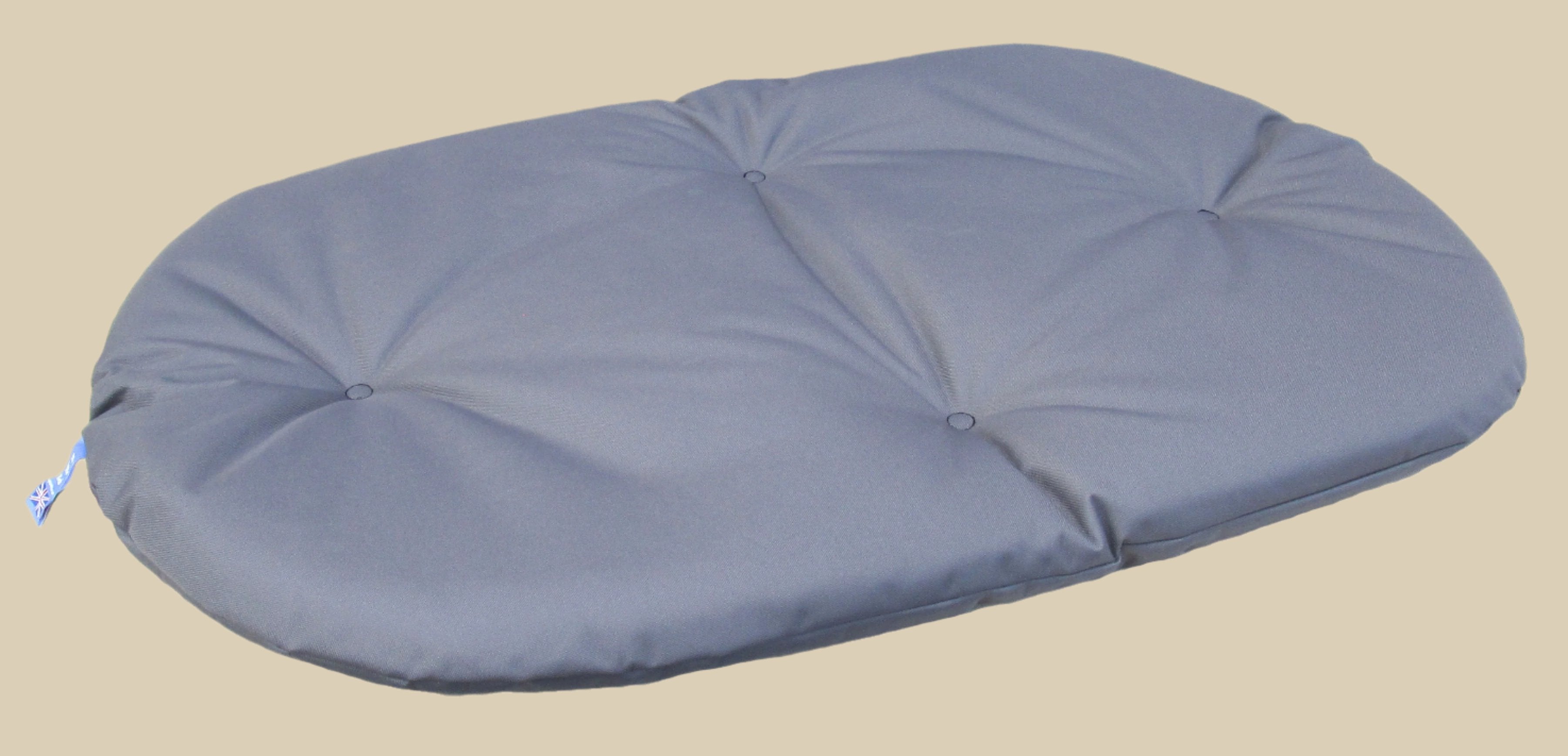 Grey waterproof oval dog bed cushion with button tufting details, heavy duty construction for comfort and durability