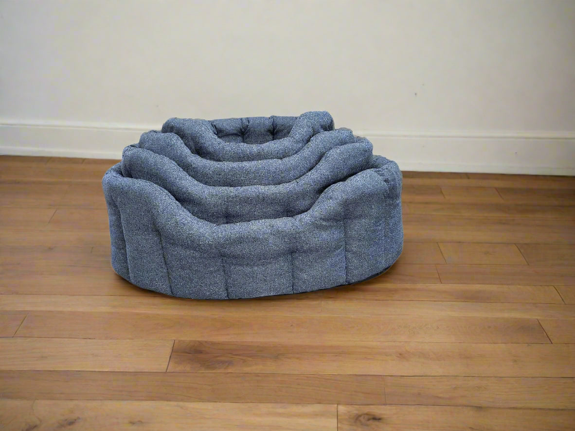 Premium Orkney Tweed oval pet beds in grey fabric, nested design showing multiple sizes on wooden floor