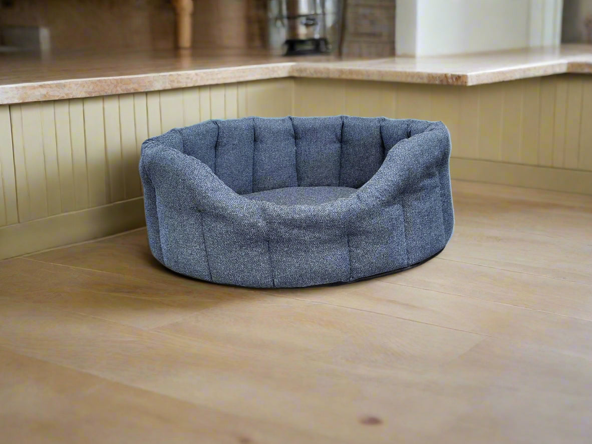 Grey Orkney tweed oval pet bed with quilted sides positioned on wooden kitchen floor showing comfortable design