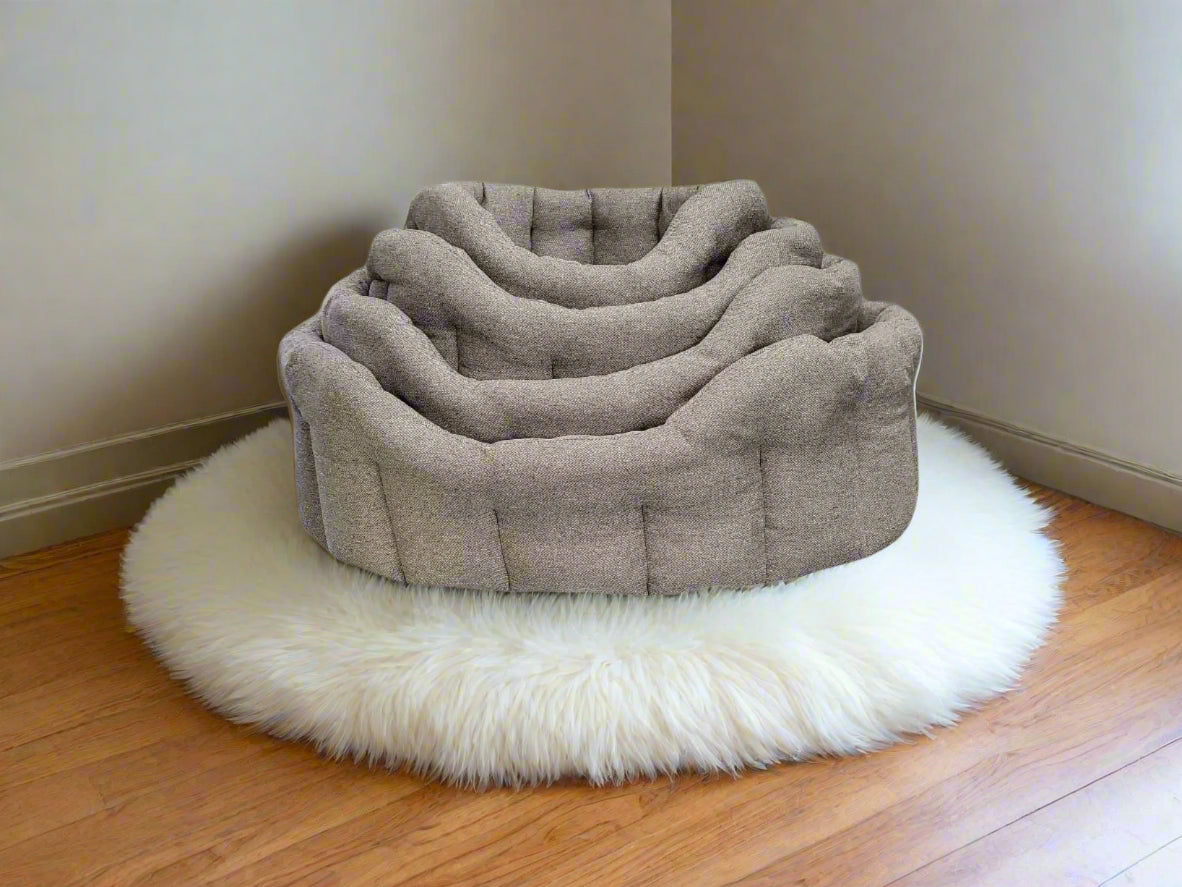 Premium Orkney Tweed Oval Pet Beds in grey fabric with button tufting, nested together on white fluffy rug