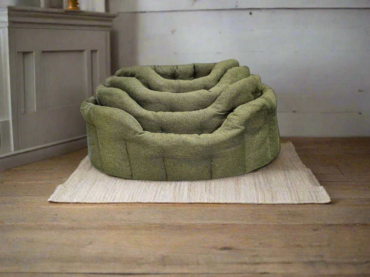 Green Orkney tweed oval pet bed with nested design on cream rug, showing quality craftsmanship and comfort