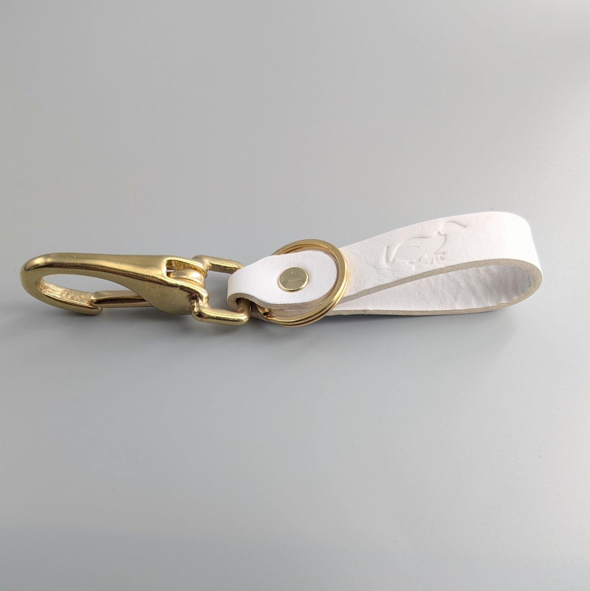 Personalised white leather keyring with gold clasp showing embossed text and premium stitching details