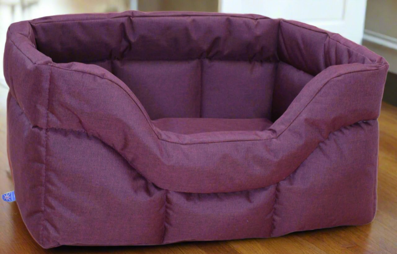 Purple waterproof rectangular dog bed with high padded sides and soft fabric upholstery on wooden floor