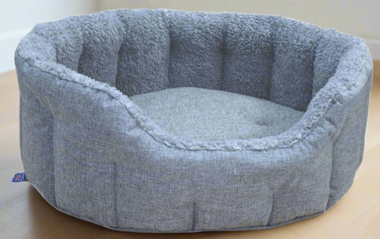 Grey oval dog bed with fleece lining and quilted bolster sides, machine washable heavy duty pet bedding