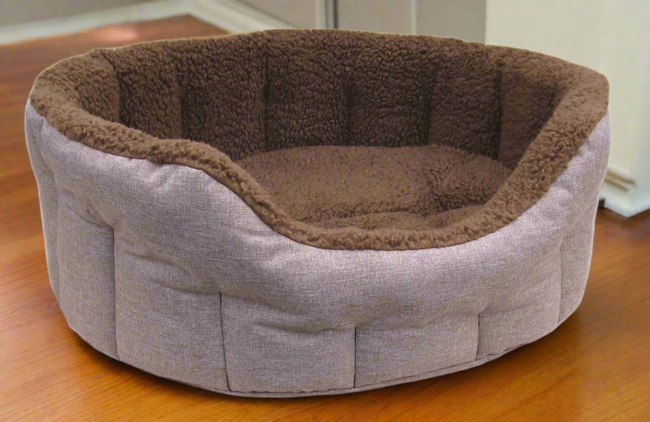 Premium oval bolster dog bed with grey outer fabric and brown fleece lining, showing quilted sides and cosy interior