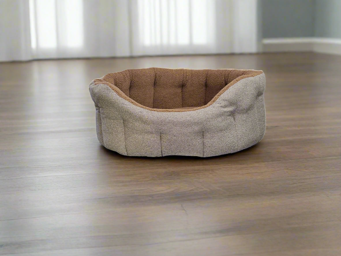Grey tweed dog bed with brown fleece lining and raised bolster sides on wooden floor in bright room
