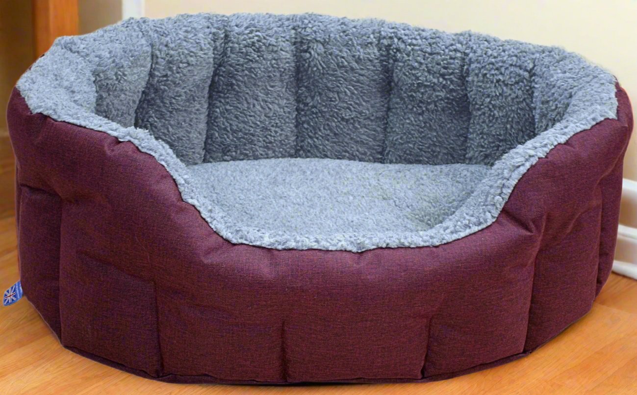 Premium burgundy oval dog bed with grey fleece lining and bolster sides, waterproof heavy duty pet bedding