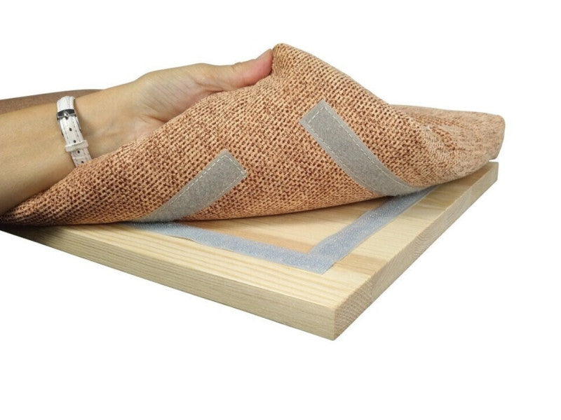 Close up of a hand lifting the Cat Window Perch fabric cover from the pine wood base