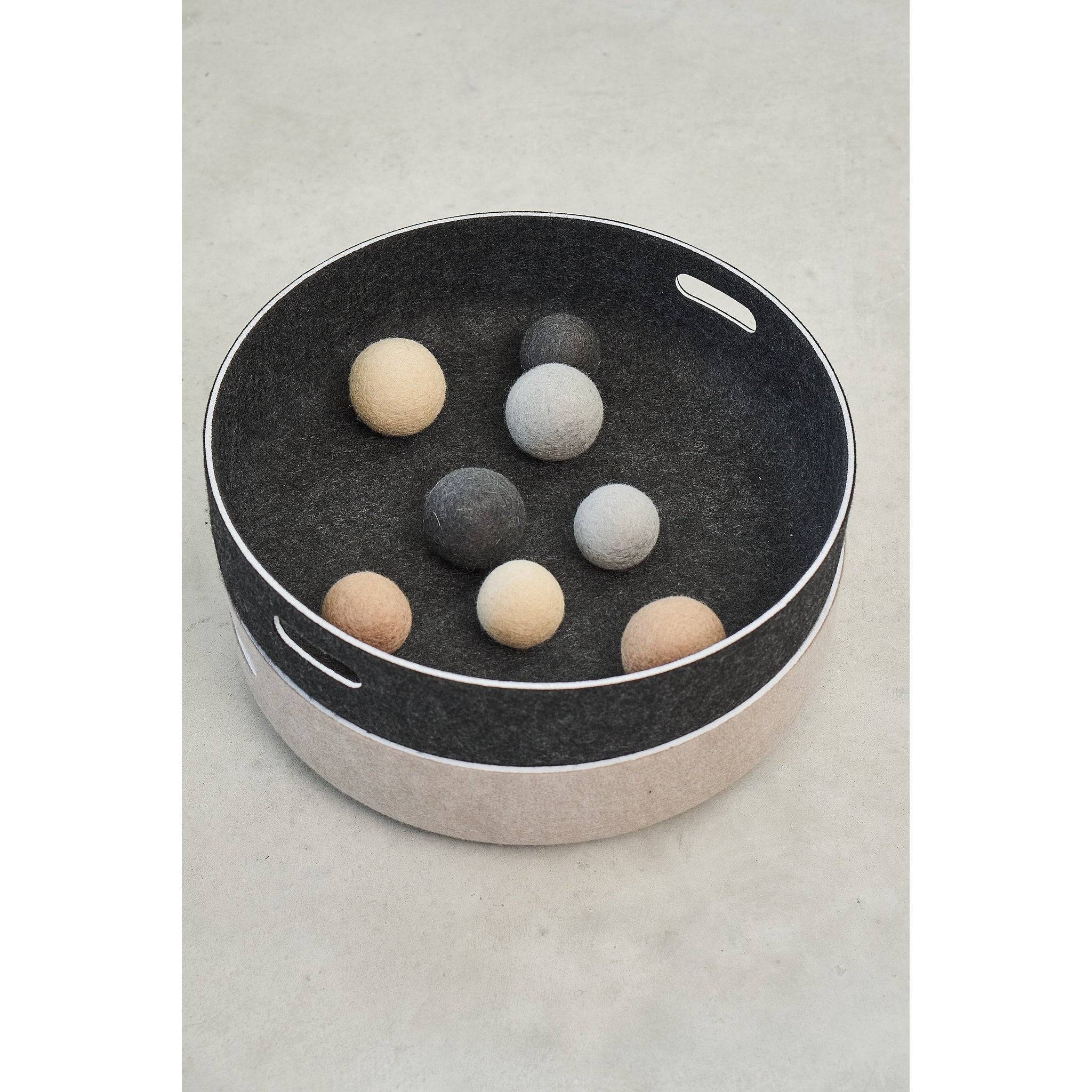 Modern pet toy basket with felt balls in minimalist German design featuring sustainable materials and clean lines