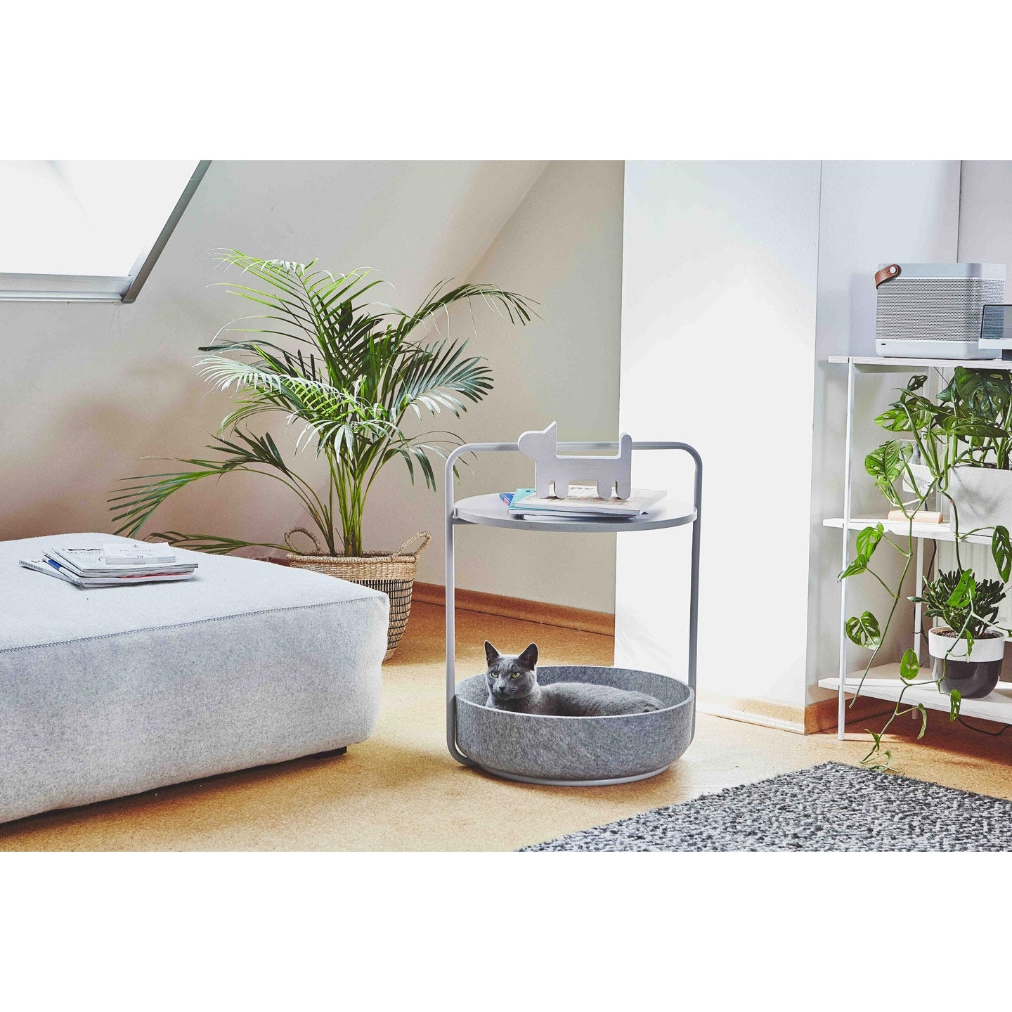 Contemporary cat side table with grey felt bed, white metal frame, featuring Russian Blue cat in modern minimalist living room