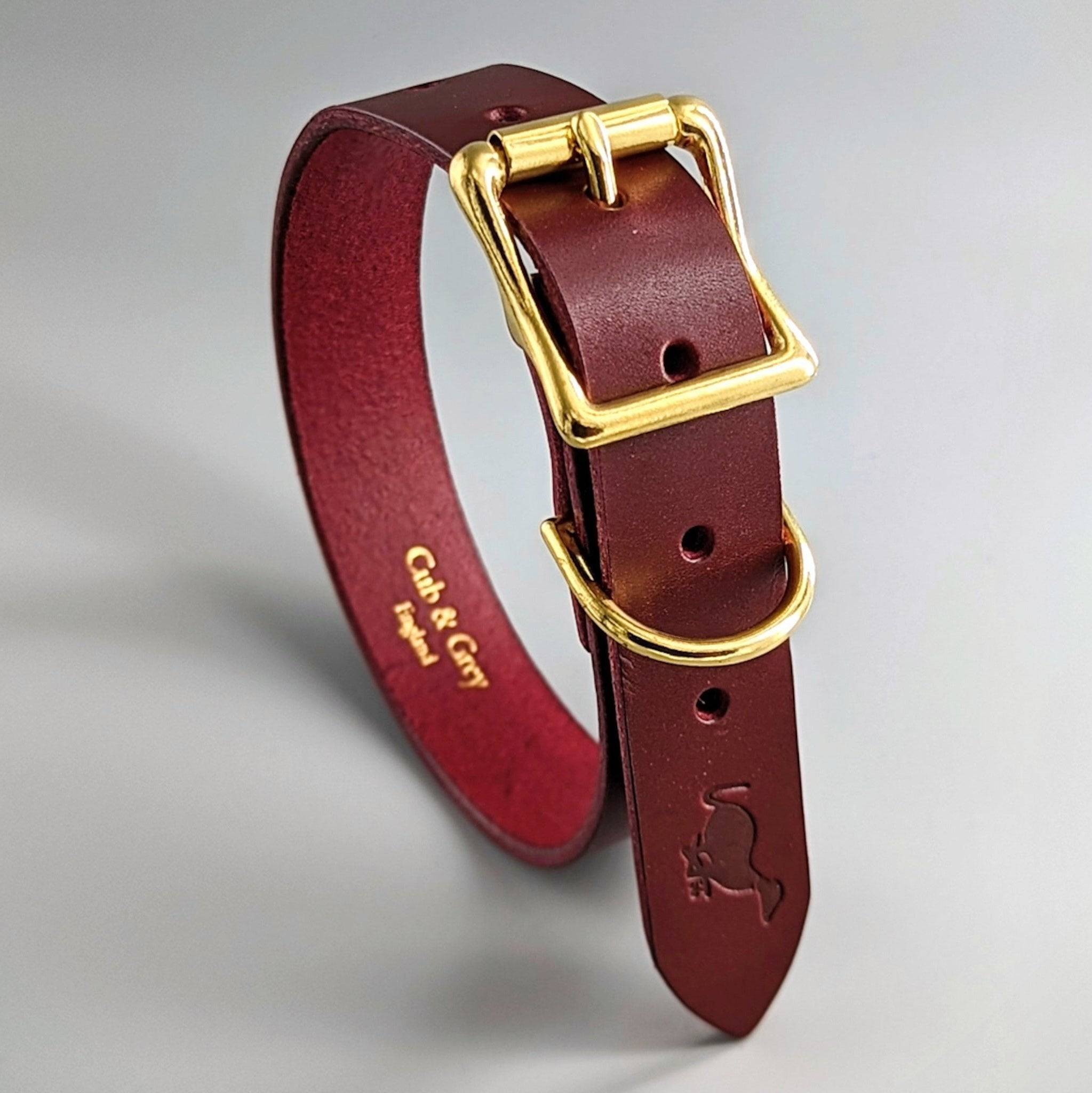 Burgundy personalised leather dog collar with gold hardware, featuring CH & GH embossed lettering and paw prints
