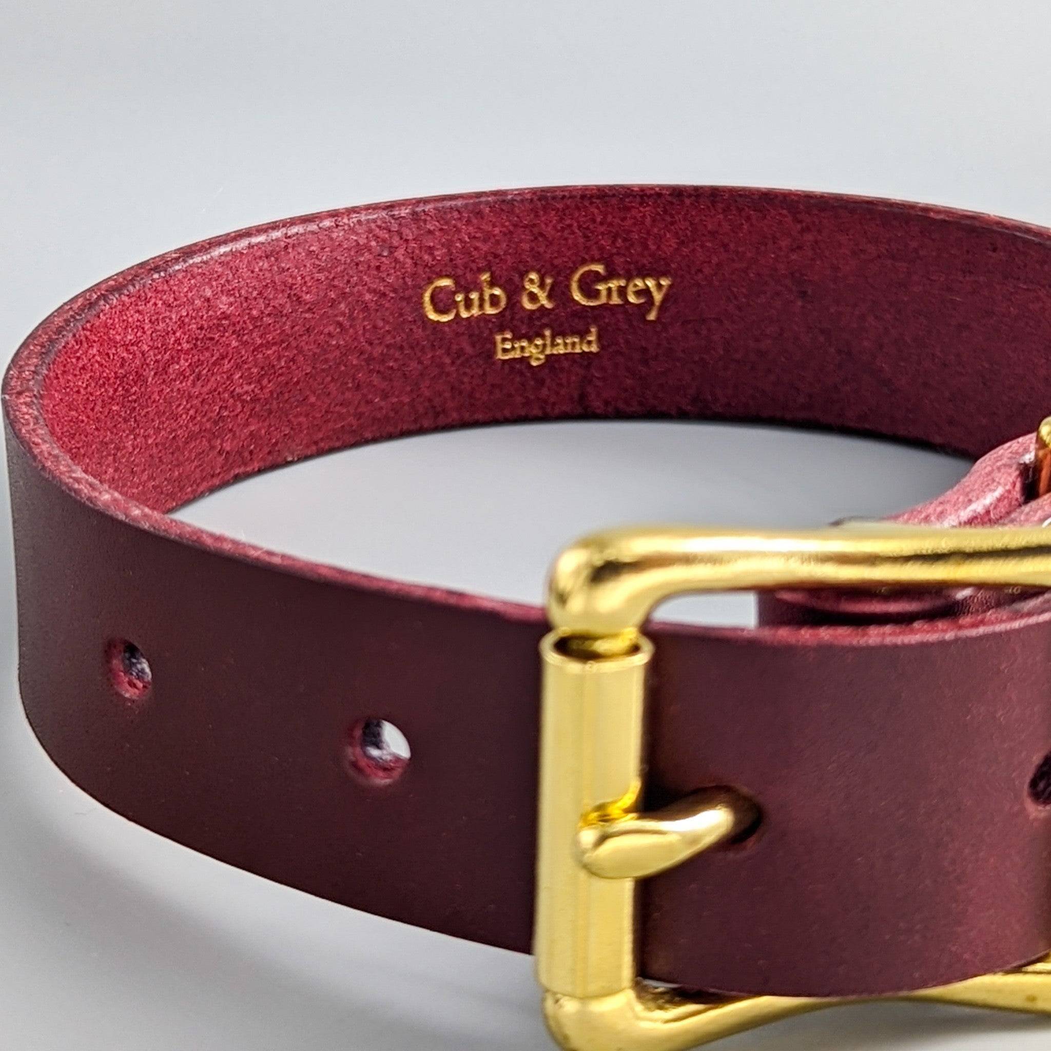 Burgundy personalised leather dog collar close-up showing gold-embossed 'Cub & Grey England' interior branding