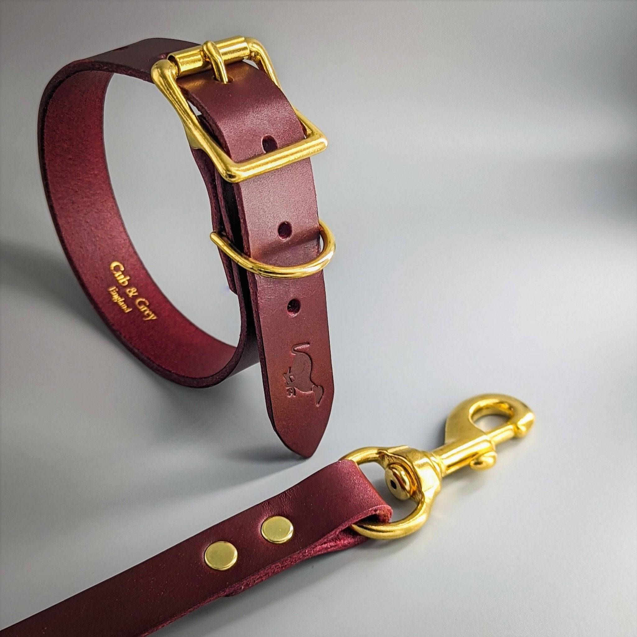 Burgundy leather dog collar and matching lead with brass hardware showing embossed interior branding details