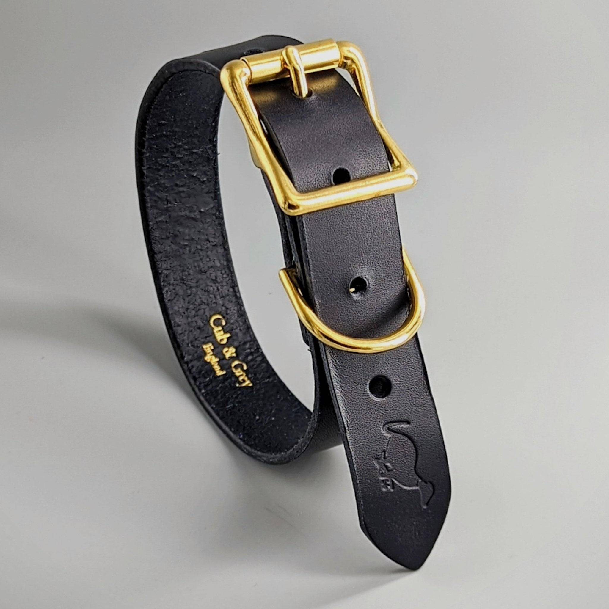 Black luxury leather dog collar with gold-tone buckle, showing City & Co embossed personalization inside