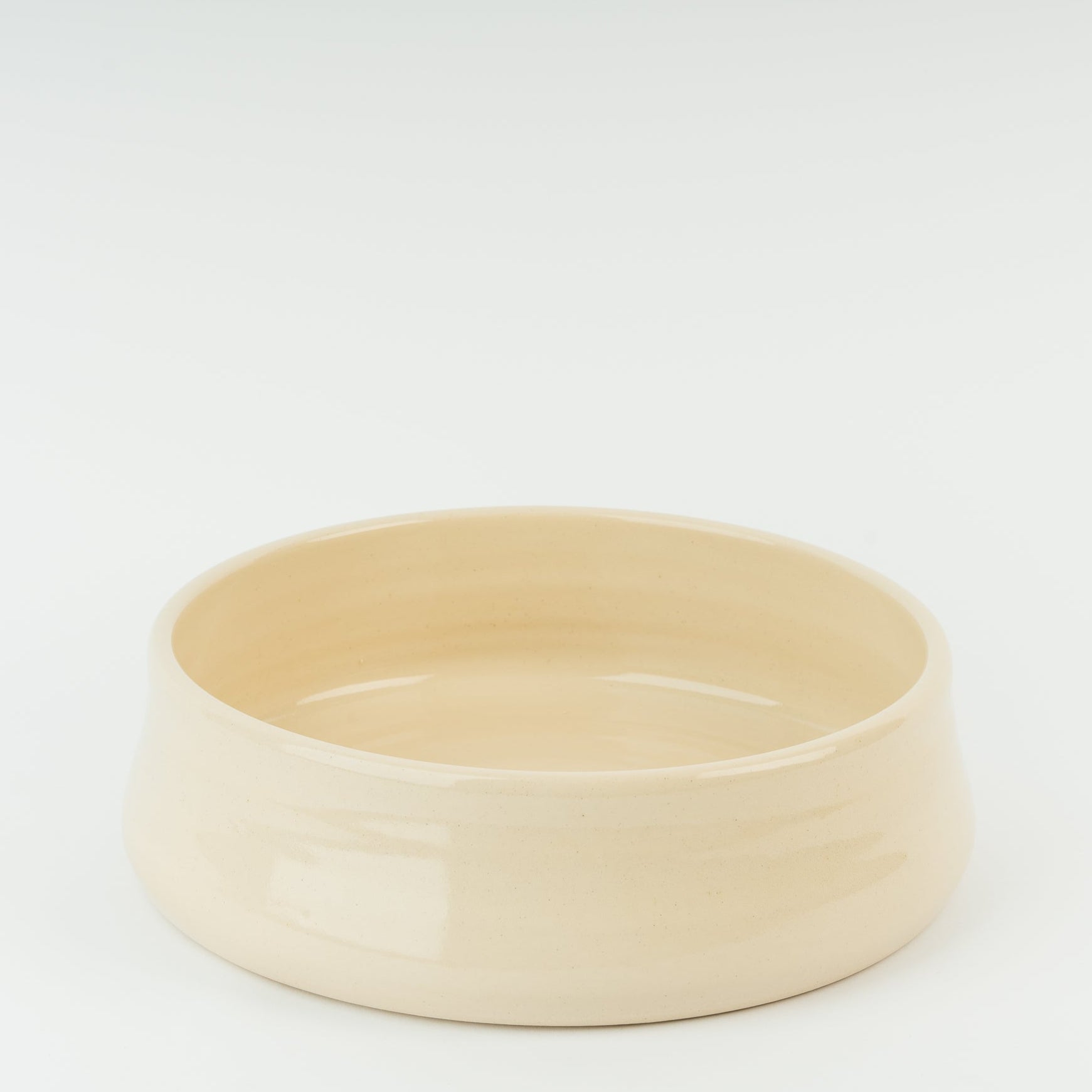 Handmade cream stoneware dog bowl showing traditional British pottery craftsmanship from Derbyshire artisans
