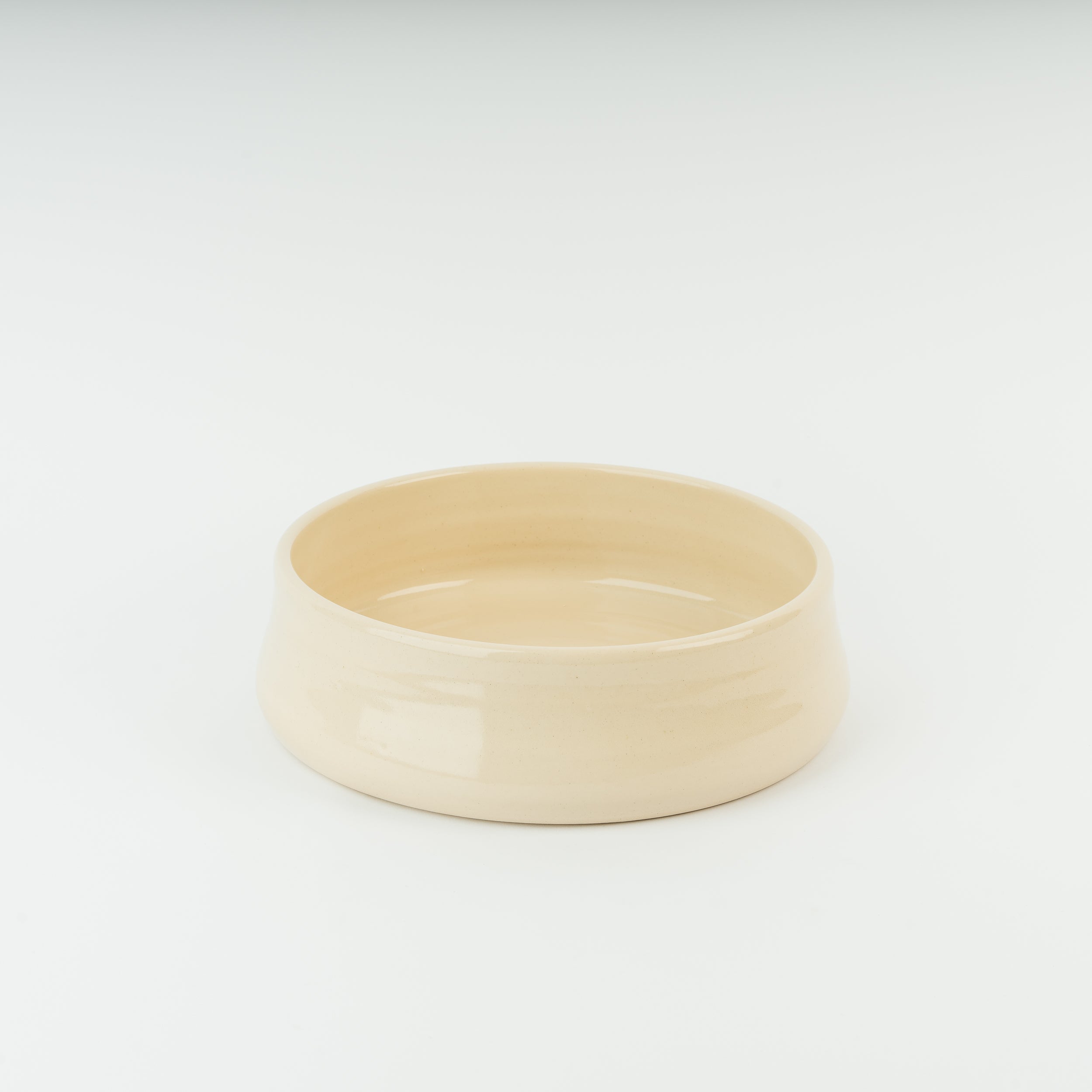 Handmade cream ceramic dog bowl in traditional British stoneware, showcasing artisan Derbyshire pottery craftsmanship
