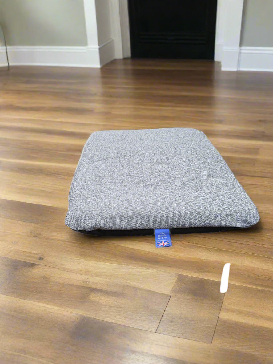 Grey Orkney tweed dog bed with removable waterproof cover on wooden floor showing British craftsmanship label