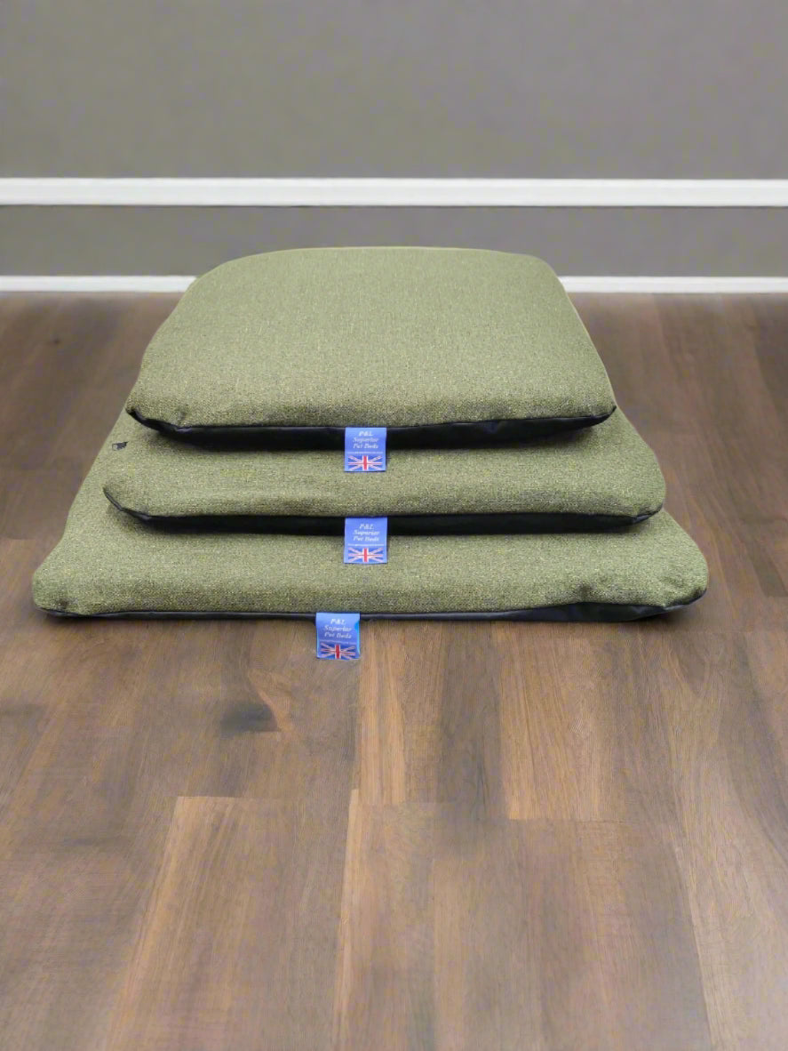 Green Orkney tweed dog bed cushions with waterproof covers stacked showing three sizes with Union Jack labels