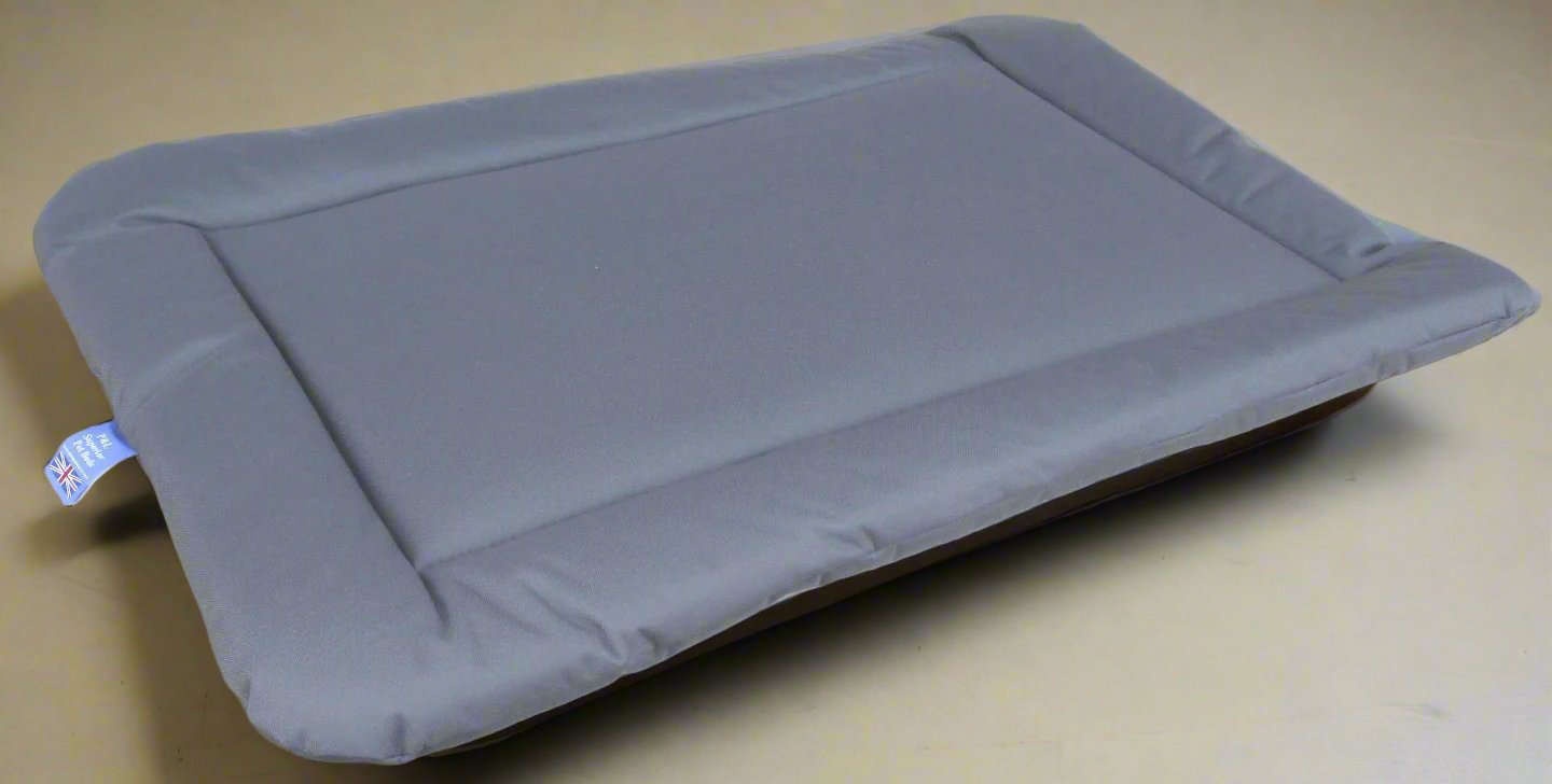 Grey waterproof rectangular dog bed cushion pad with padded borders on beige background - heavy duty design