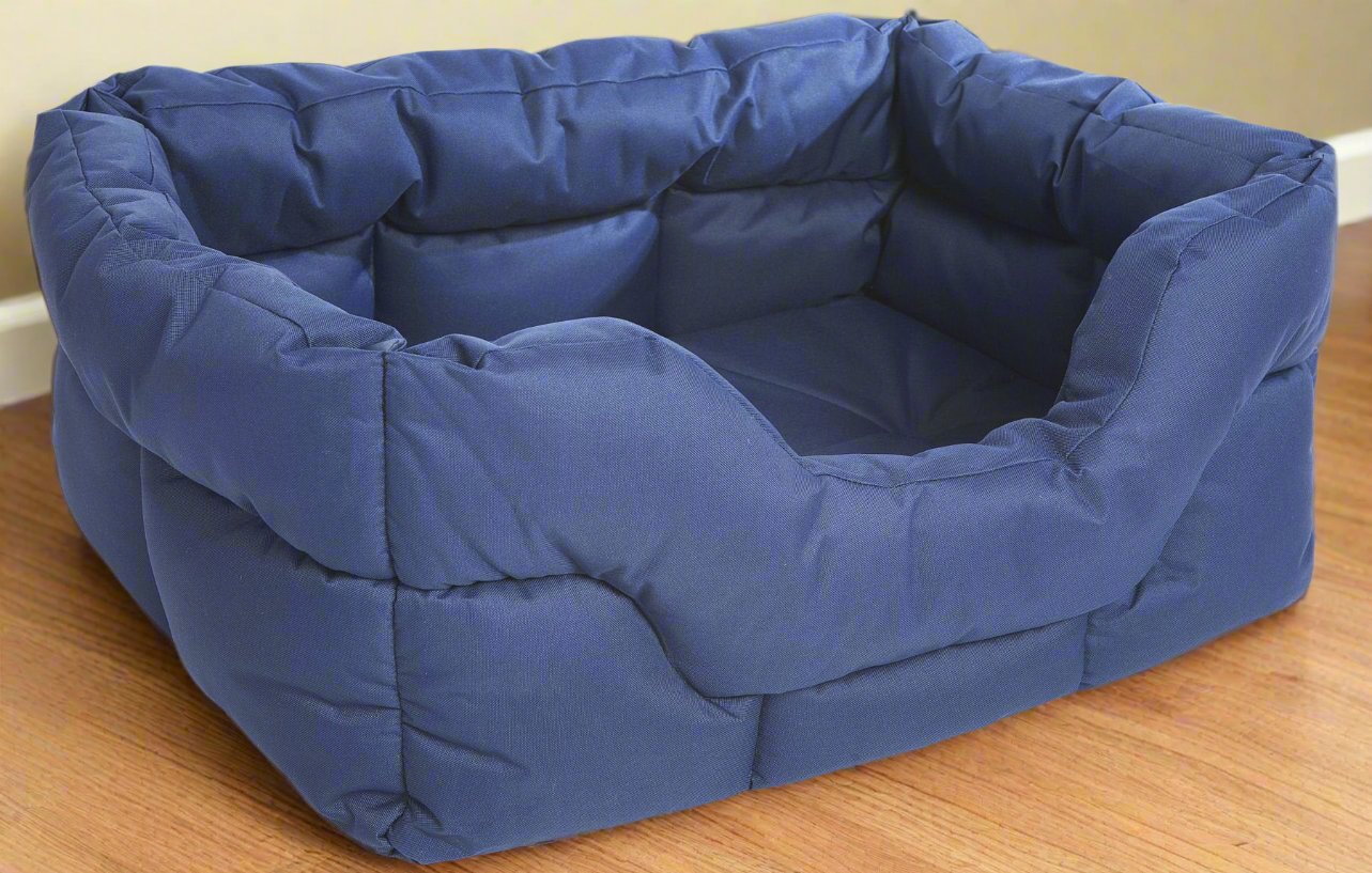Navy blue rectangular high-sided waterproof dog bed with quilted padding on wooden floor for comfort