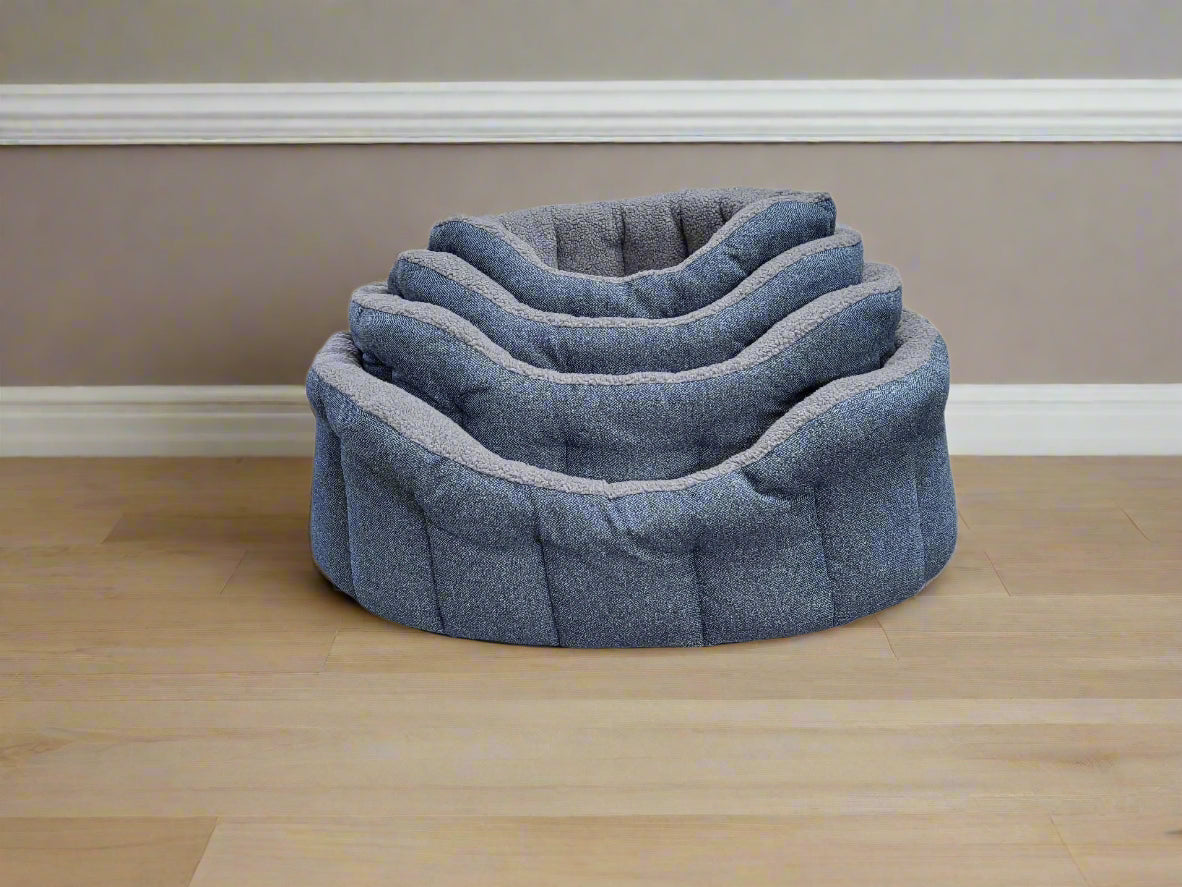 Premium Orkney tweed dog bed with fleece lining and raised bolster sides in blue-grey fabric on wooden floor