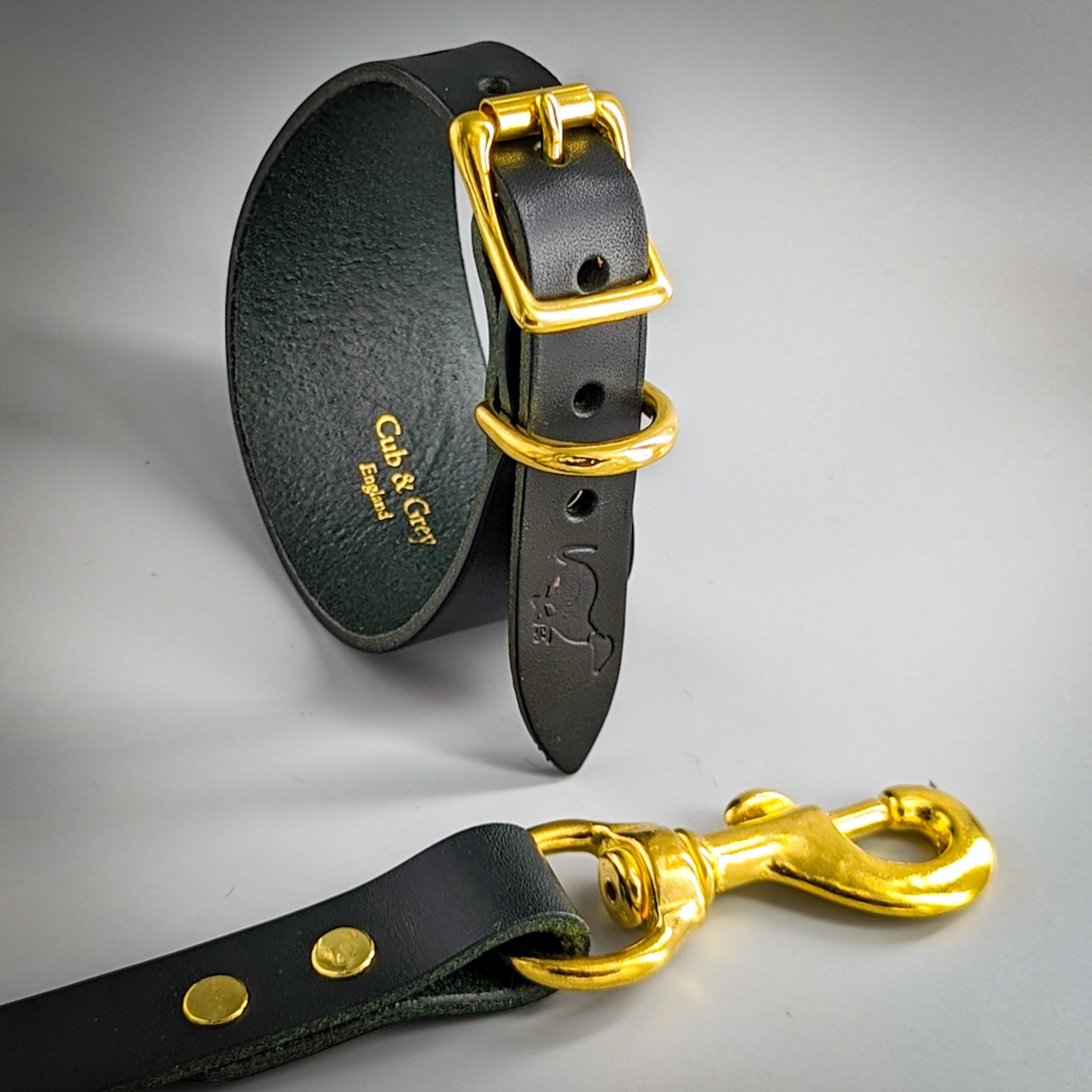 Dark green leather whippet collar and lead set with brass hardware showing Cub & Grey England branding