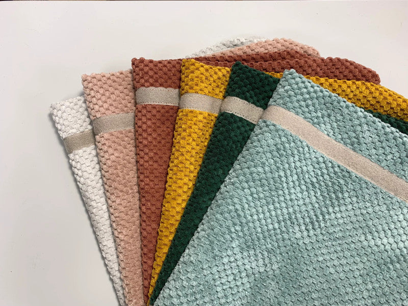 Stack of textured fabric mattress covers in white, pink, rust, yellow, green and blue for metal base pet shelves