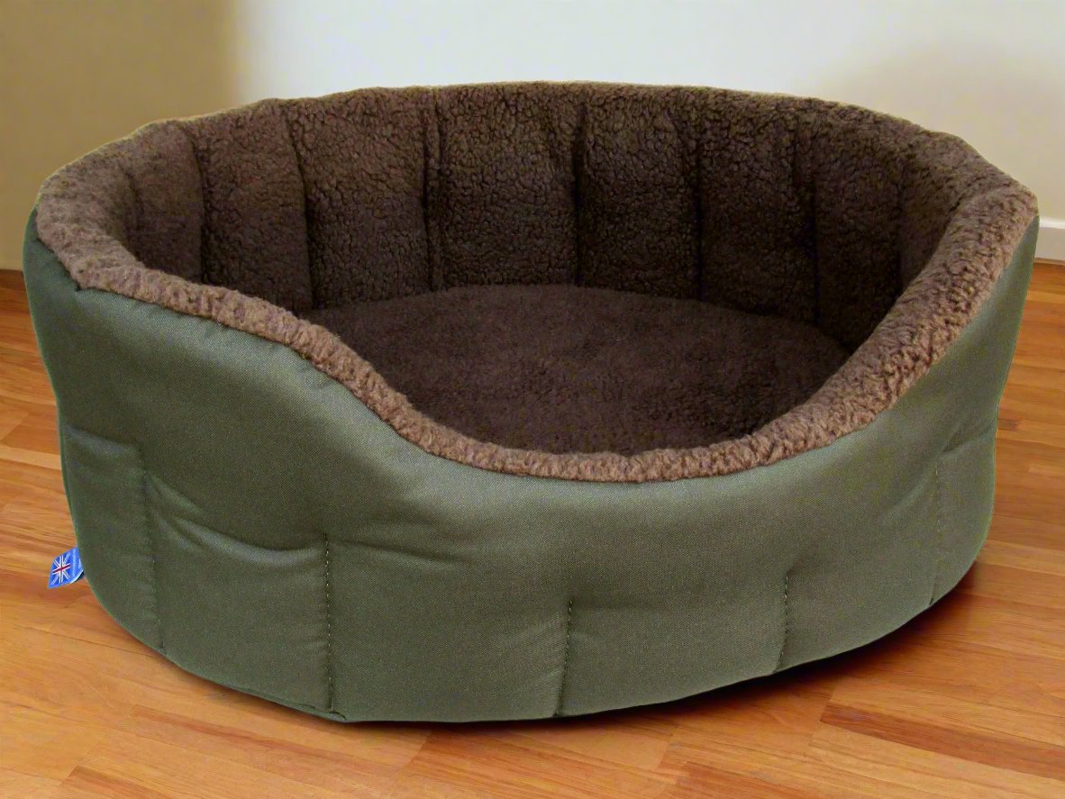 Oval green canvas dog bed with brown fleece lining and quilted sides on wooden floor - machine washable design