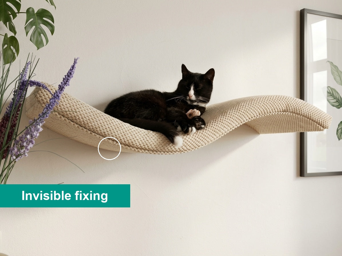 Lifestyle shot of a black and white cat on a beige Cat's Atelier Wave cat shelf